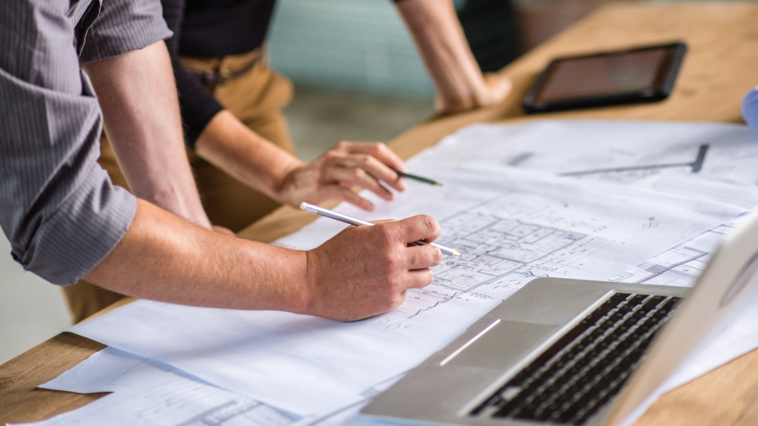 Architects discussing on blueprint at construction site.